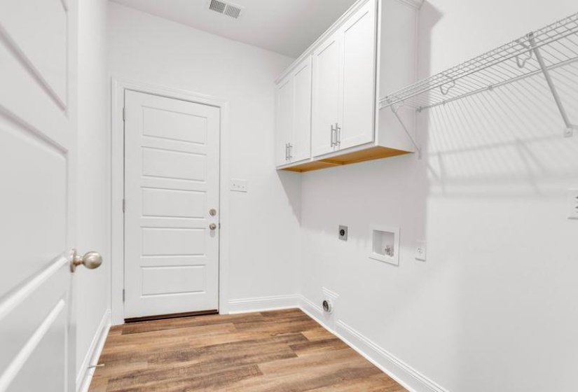 Laundry area with light wood-style flooring, hookup for an electric dryer, cabinet space, and hookup for a washing machine