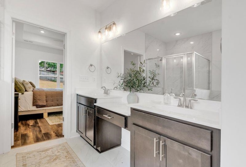 Bathroom with double vanity, ensuite bathroom, a marble finish shower, light marble finish floors, and recessed lighting