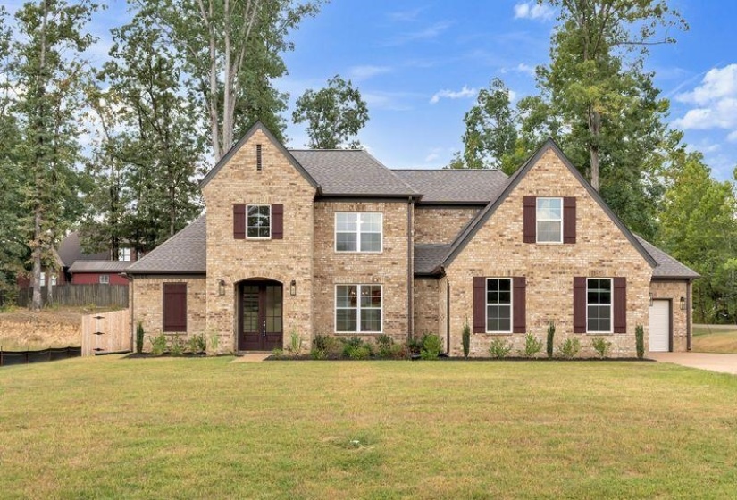 Tudor house with brick siding, a front lawn, and a shingled roof