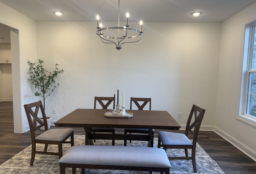 Dining room with dark wood finished floors, a chandelier, and recessed lighting