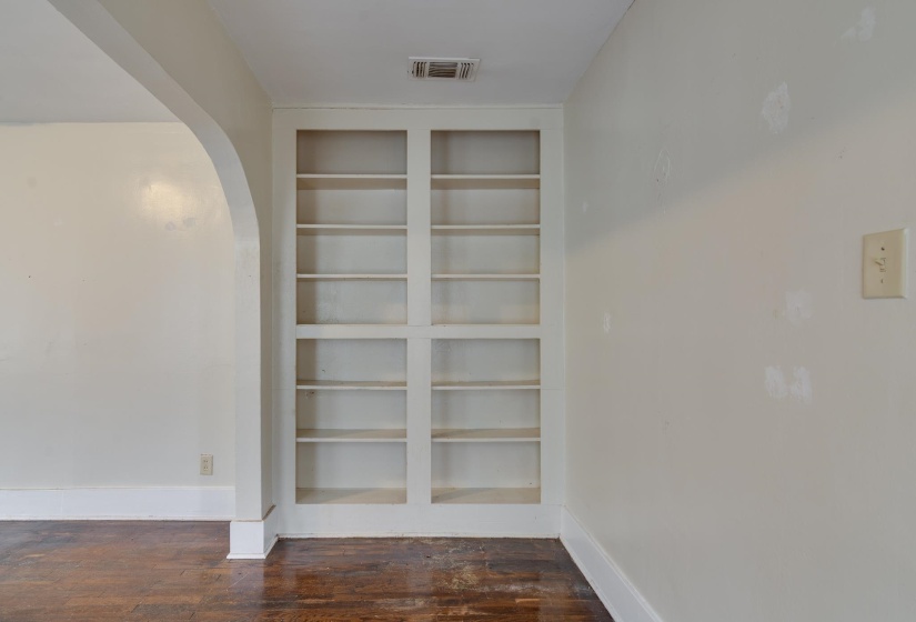 Detailed view of built in shelves, arched walkways, and wood finished floors