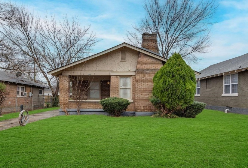 Bungalow-style home with a chimney and brick siding