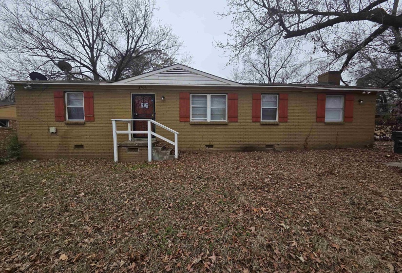View of front of house with crawl space, a chimney, and brick siding