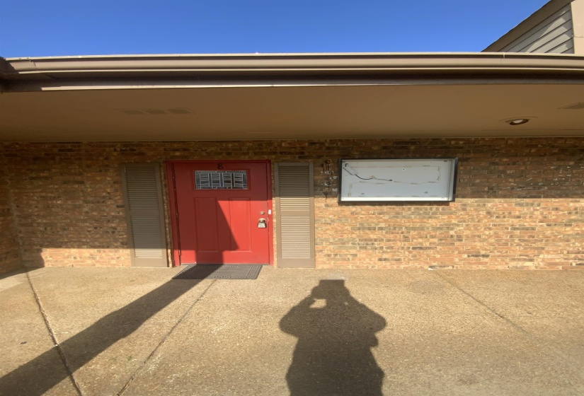 Doorway to property featuring brick siding and a patio area