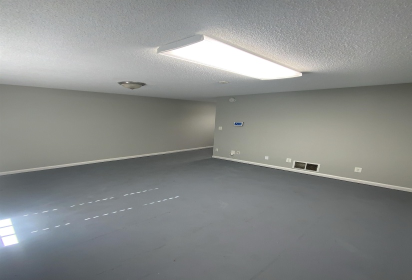 Spare room featuring a textured ceiling and dark carpet
