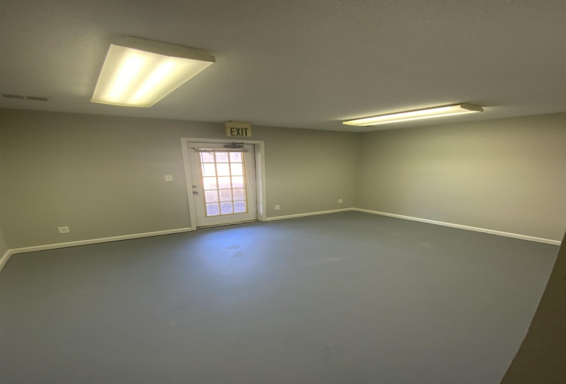 Empty room with finished concrete floors and baseboards
