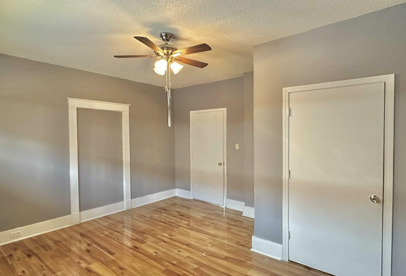 Unfurnished bedroom with light wood-style flooring, a textured ceiling, and ceiling fan