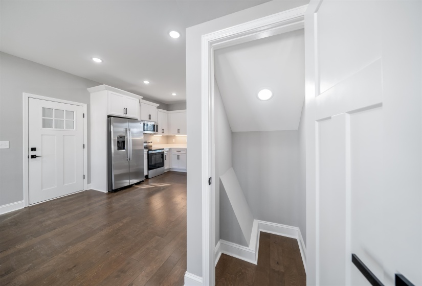 Stairway with recessed lighting and wood finished floors