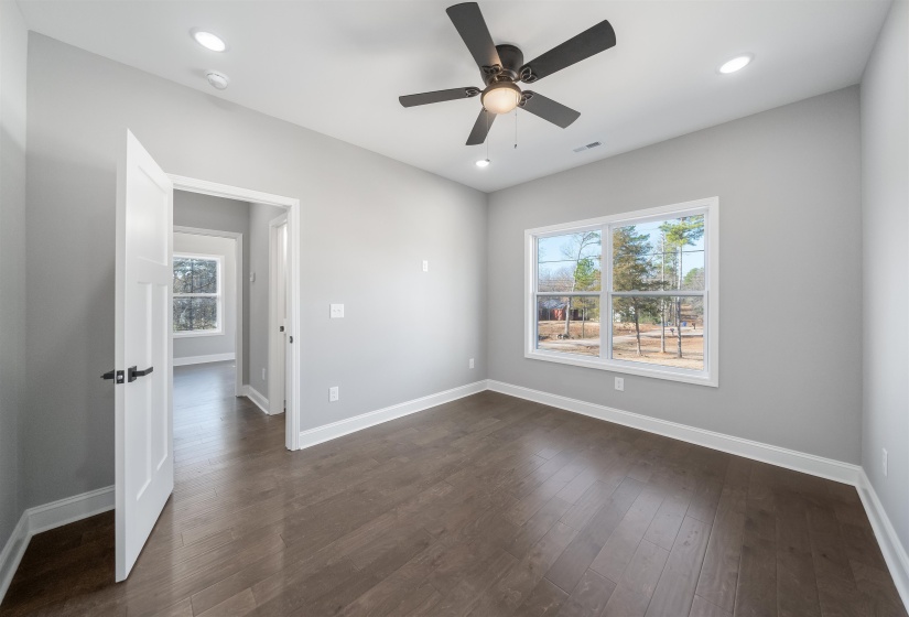 Spare room with dark wood-type flooring, a ceiling fan, and recessed lighting
