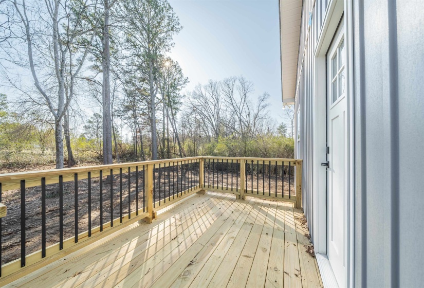 Wooden terrace featuring view of scattered trees