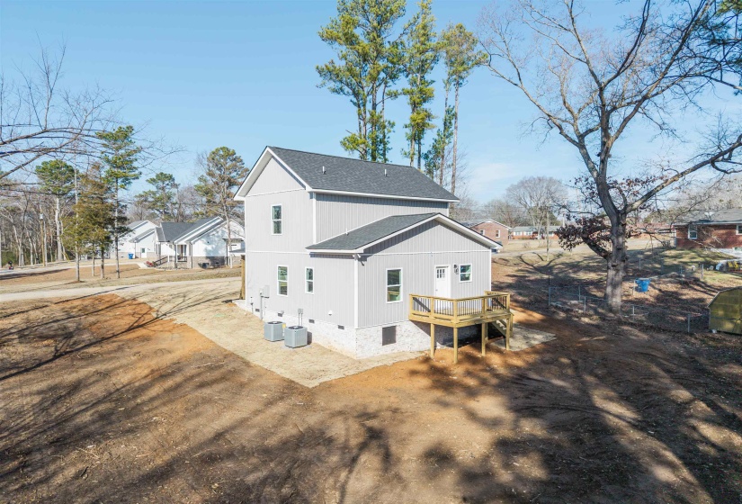 Rear view of house featuring a wooden deck and a shingled roof