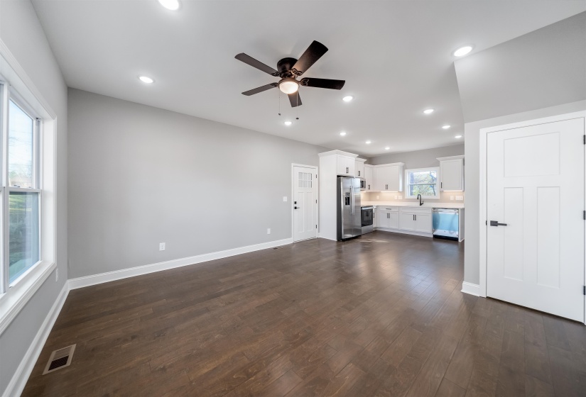 Unfurnished living room with a ceiling fan, dark wood-style floors, and recessed lighting