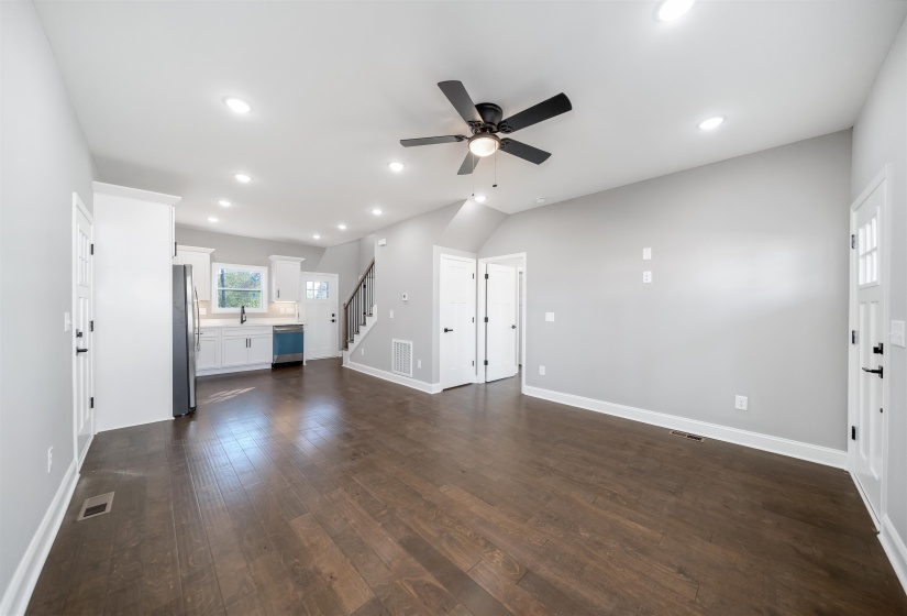 Unfurnished living room with stairway, recessed lighting, a ceiling fan, and dark wood-type flooring