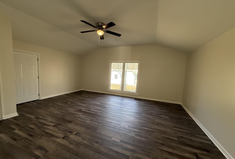 Masterb= bedroom with vaulted ceiling, dark wood-style flooring, and ceiling fan