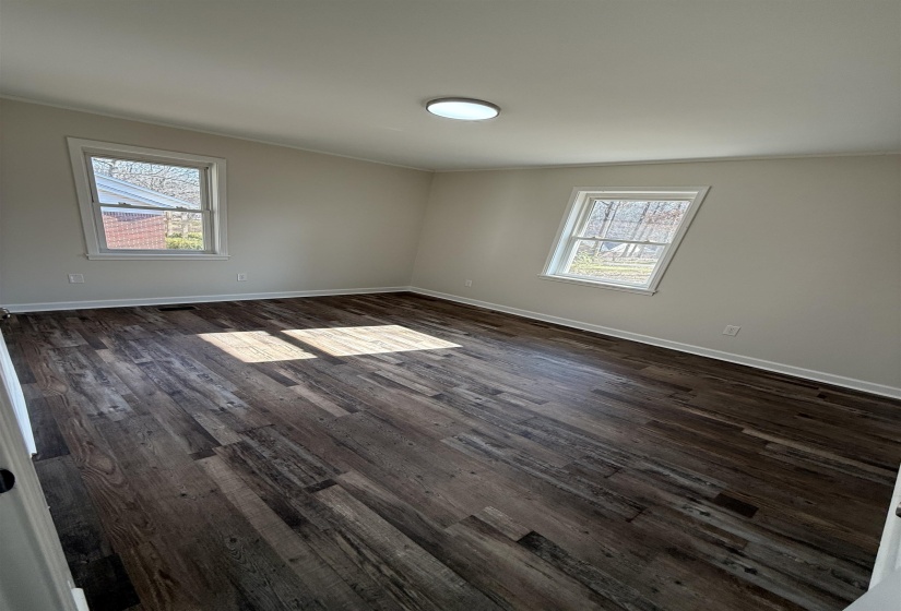 Guest room featuring plenty of natural light, dark wood finished floors, and crown molding
