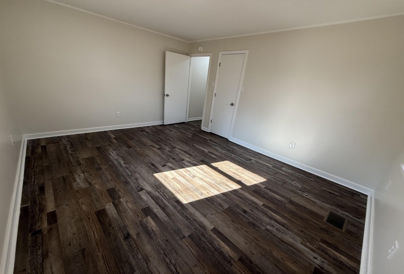 bedroom with dark wood-style floors and crown molding