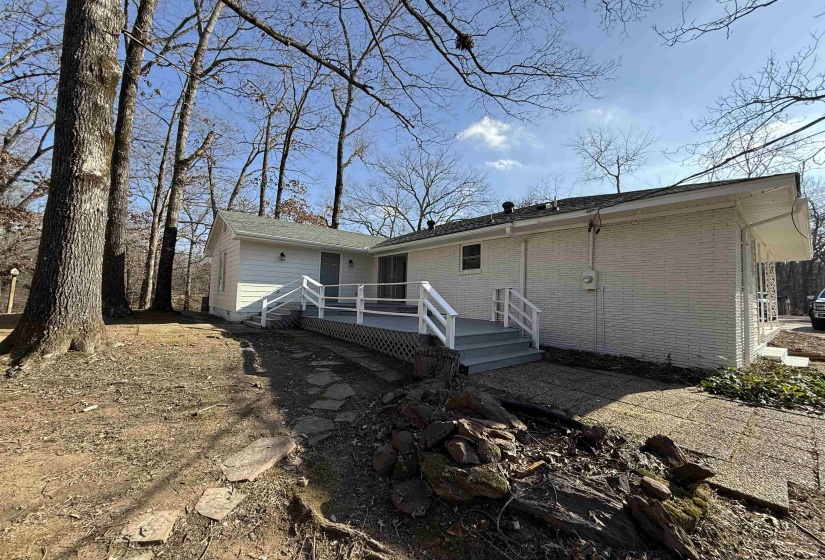 Back of property with brick siding and a wooden deck