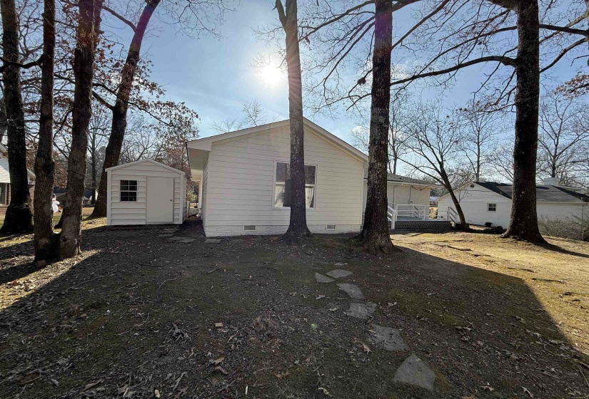 View of side of property featuring a storage unit, crawl space, and a deck