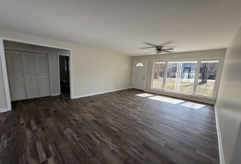 Unfurnished living room with dark wood-type flooring and ceiling fan