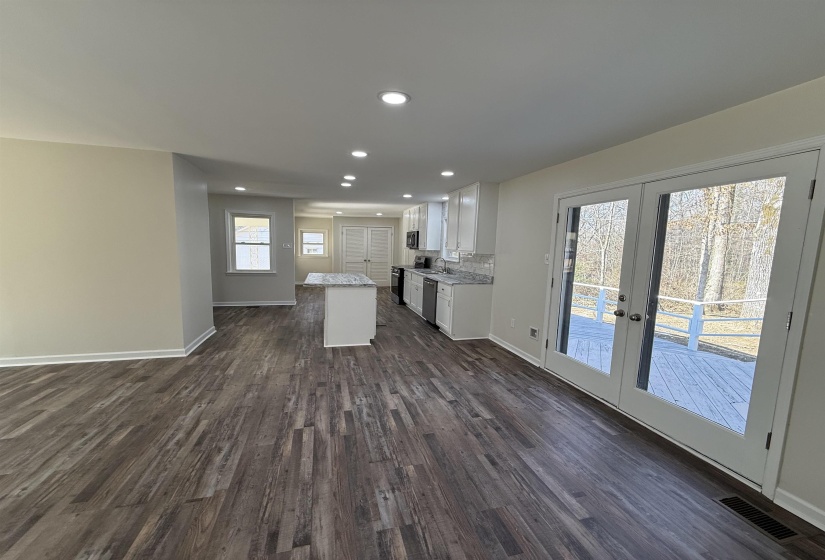 Kitchen featuring white cabinets, french doors, open floor plan, a kitchen island, and dark wood-style floors