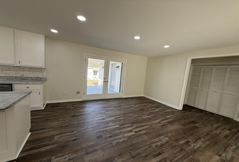 Unfurnished dining area with recessed lighting, dark wood-style floors, and french doors