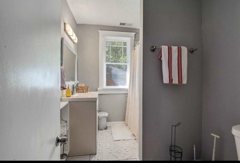 Bathroom featuring a single vanity with countertop, framed mirror, and integrated lighting