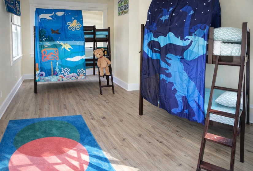 Spacious room featuring wood-finish flooring, light-toned wall paint, and white trim