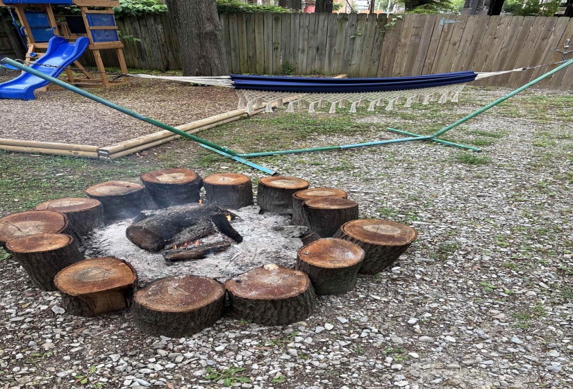 Outdoor gravel fire pit area with log seating
