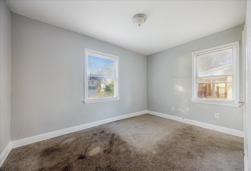 Carpeted empty room featuring baseboards