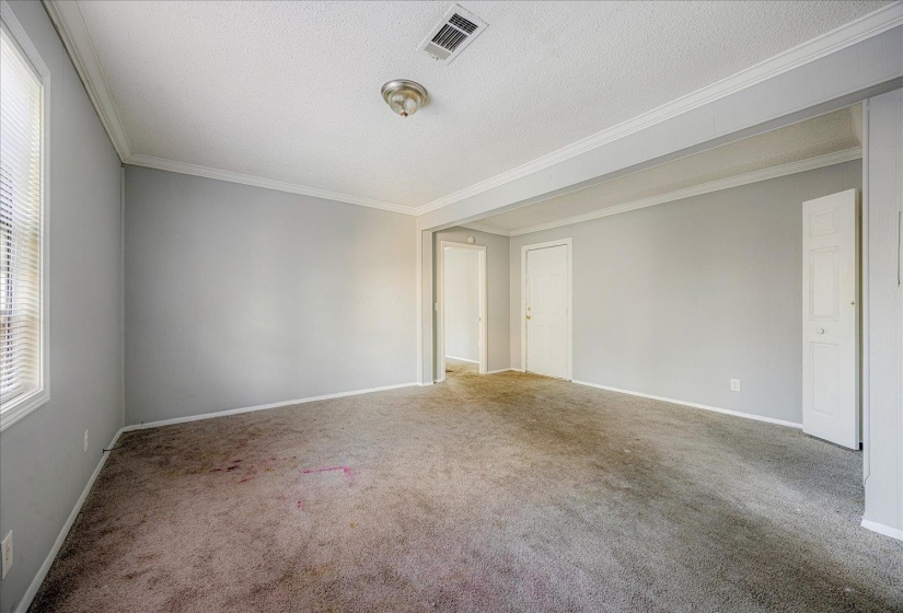 Carpeted spare room featuring ornamental molding and a textured ceiling