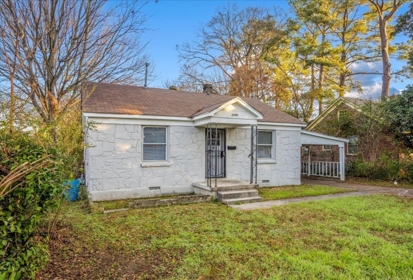 Bungalow featuring a front lawn, a carport, crawl space, roof with shingles, and stone siding