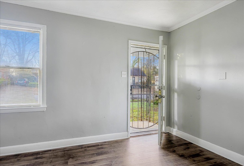 Entrance foyer with crown molding and wood finished floors