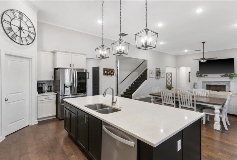 Kitchen with dark cabinets, dishwasher, and seamless connection to dining and living area.