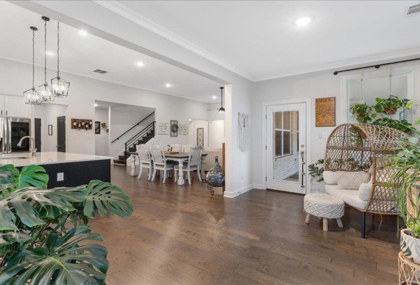 Living area with stairway, dark wood-type flooring, recessed lighting, and crown molding