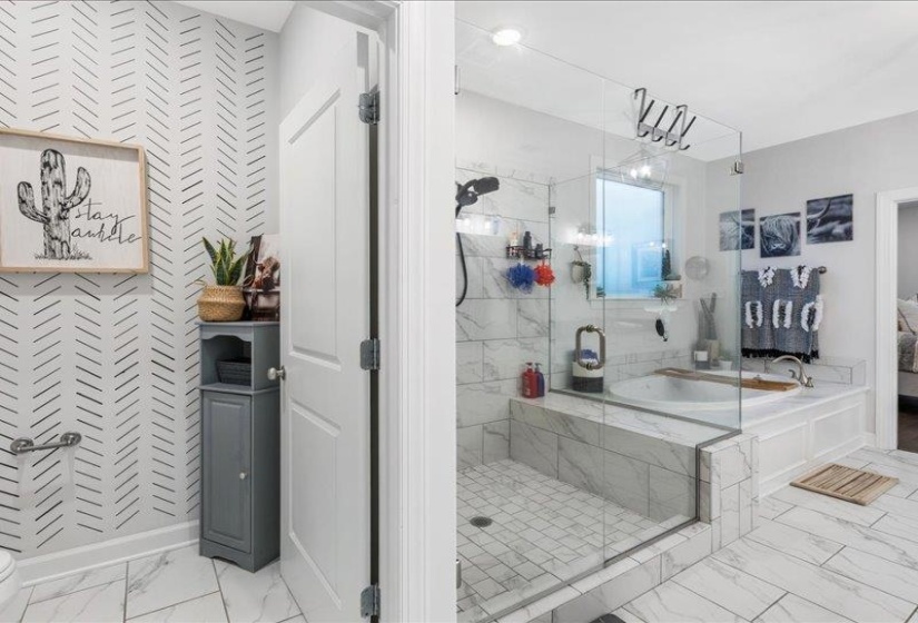 Ensuite bathroom featuring light marble finish floors, a bath, a shower and soaking tub.