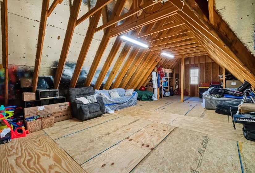 Fully floored attic offering extensive storage space with lighting.