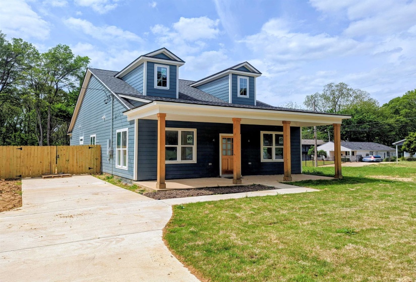 View of front of property featuring a porch, a front lawn, concrete driveway, a gate, and roof with shingles