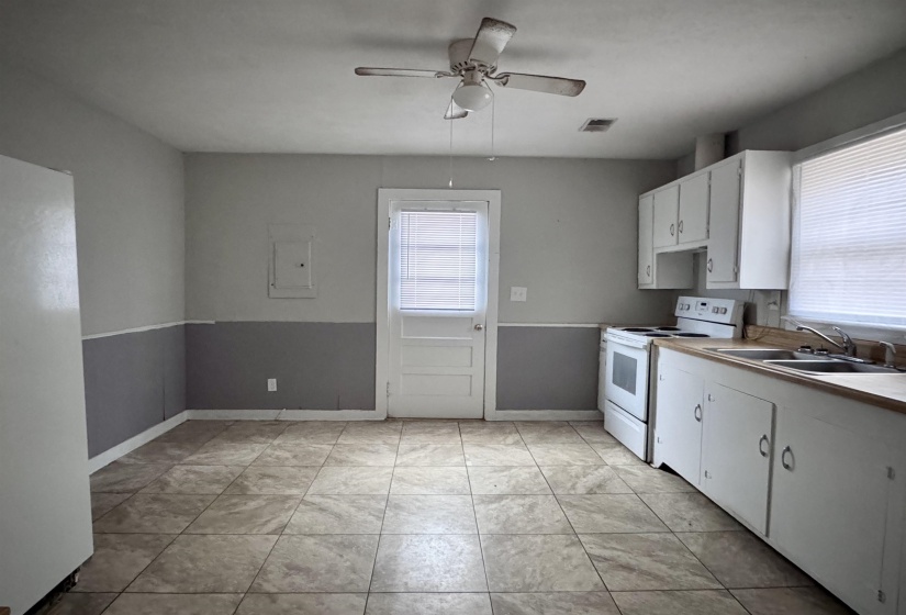 Kitchen featuring white cabinets, white range with electric stovetop, light countertops, and a ceiling fan