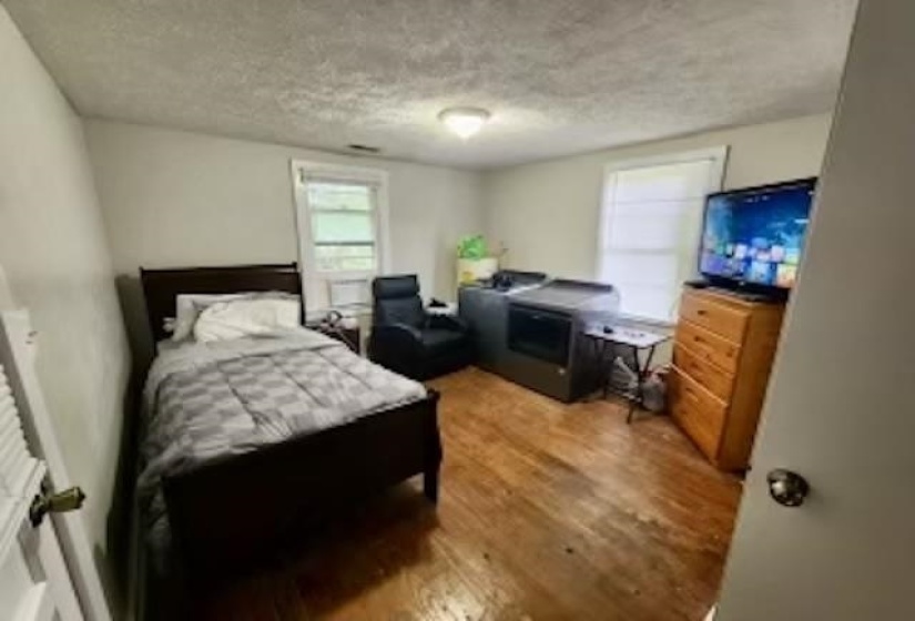 Bedroom featuring a textured ceiling and hardwood / wood-style flooring