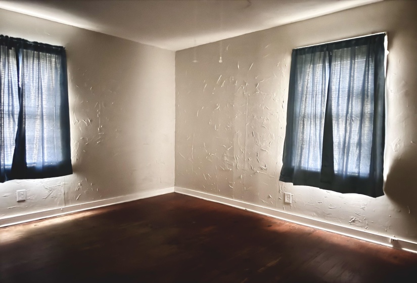Spare room with a textured wall and wood finished floors