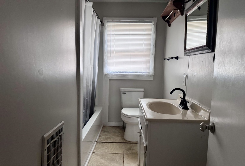 Full bathroom featuring vanity, shower / tub combo, and light tile patterned floors