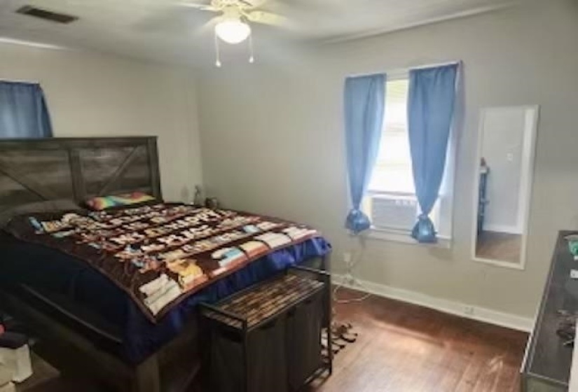 Bedroom with ceiling fan and hardwood / wood-style floors