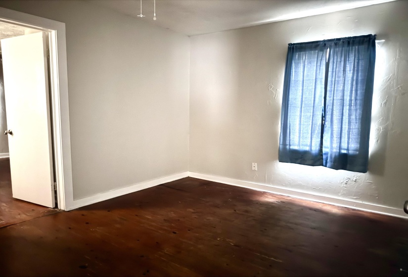 Unfurnished room with dark wood-style floors and baseboards