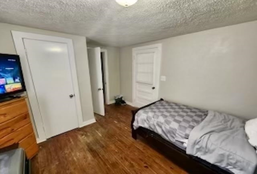 Bedroom with dark wood-type flooring and a textured ceiling