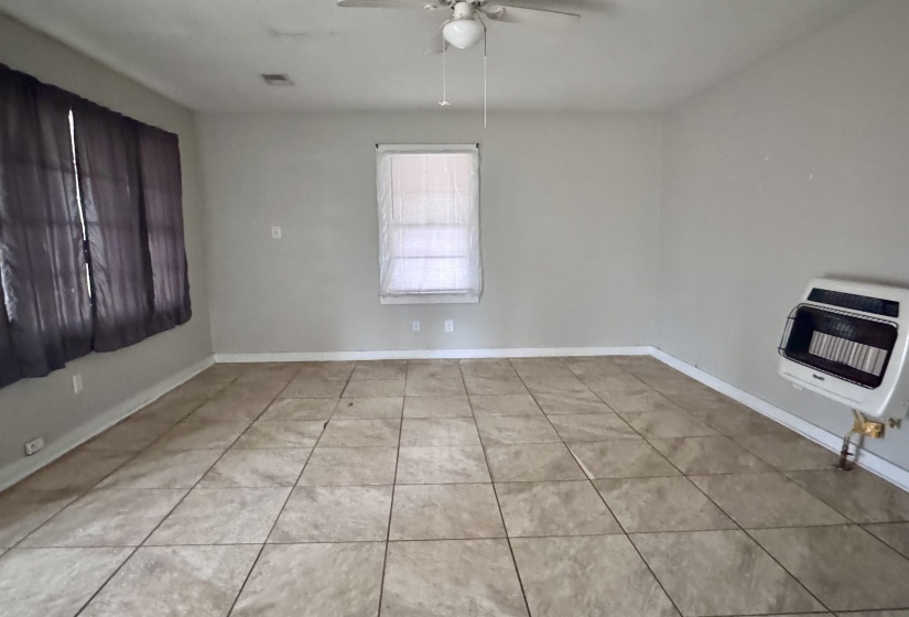 Spare room with heating unit, ceiling fan, and light tile patterned floors