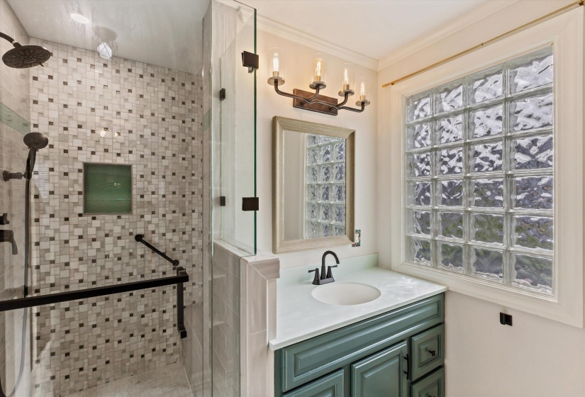 Bathroom featuring a shower stall, vanity, and crown molding