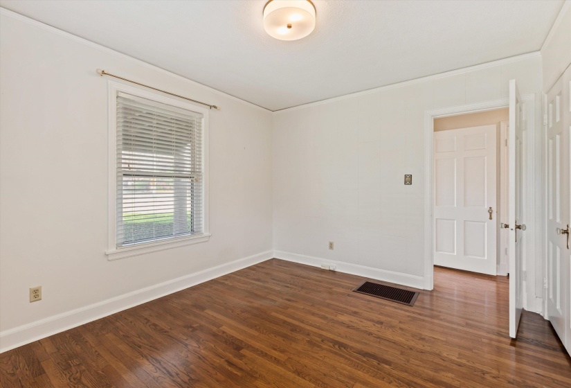 Unfurnished room with dark wood-style flooring and crown molding