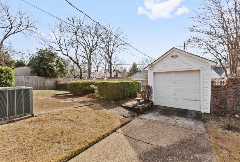 Detached garage featuring concrete driveway