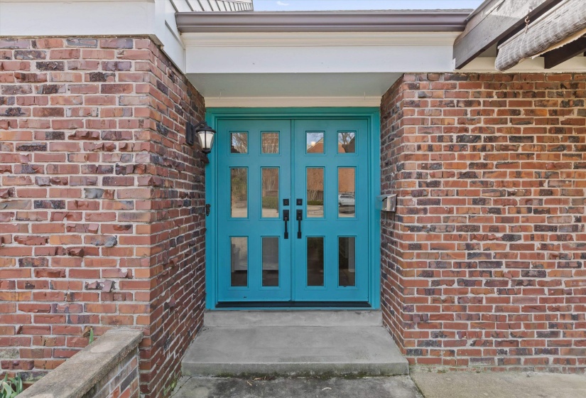 Entrance to property with brick siding and steel french doors
