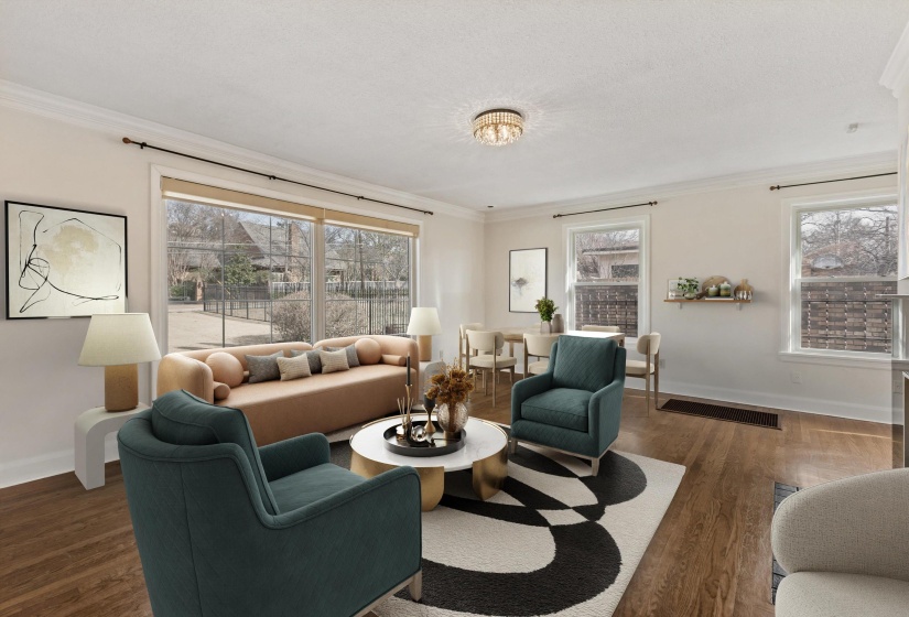 Living area featuring ornamental molding, dark wood-type flooring, and plenty of natural light. (Virtually staged)
